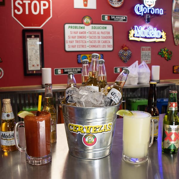 A Guanataco bar with a bucket of Corona beers, a michelada, and a margarita.