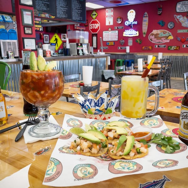 Mexican coctel de camaron, tostadas, and drinks on a table at Guanataco restaurant.