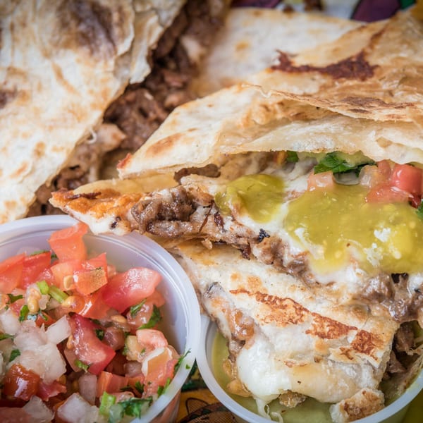 Guanataco's quesadilla with melted cheese, meat, green sauce, and a side of pico de gallo.